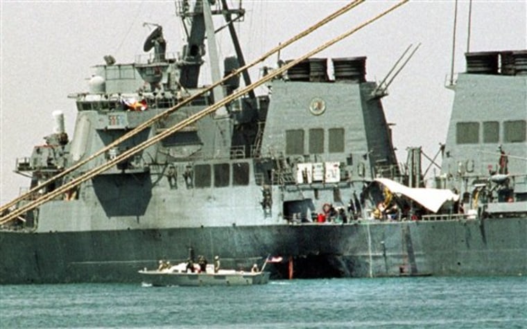 FILE -  In this Oct. 20, 2000 file photo, a small boat guards the USS Cole in Aden, Yemen. A hidden network of American companies headed by a prominent defense contractor played a central role in the CIA’s secret post-9/11 airlift that whisked captured terror suspects and their American minders to overseas prisons, according to testimony and documents filed in an upstate New York court case.  (AP Photo/Hasan Jamali, File)